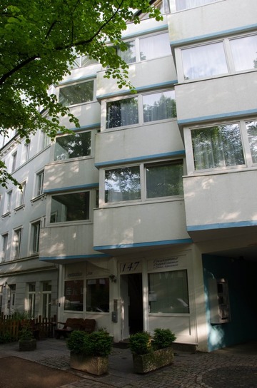 Frontansicht des Appartementhauses mit Einfahrt und Hotelomat